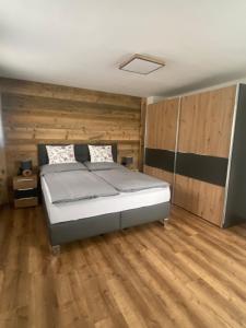a bedroom with a bed and a wooden floor at APARTMENT DACHSTEIN - neu im Haus Wieseneck in Ramsau am Dachstein