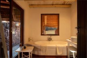 a bathroom with a tub and a window at Zebras Crossing in Modimolle