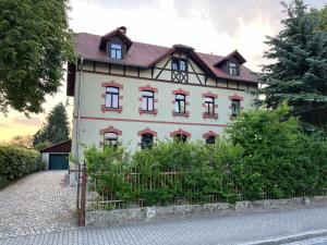 a large white house with a gambrel roof at Ferienwohnung Am Bürgerteich in Bischofswerda