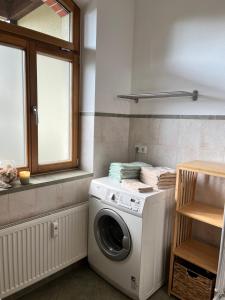 a washing machine in a kitchen with a window at Ferienwohnung Am Bürgerteich in Bischofswerda
