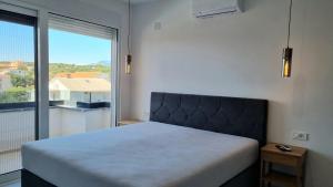 a bedroom with a bed and a large window at Apartments Roxsi in Novalja +122 photos