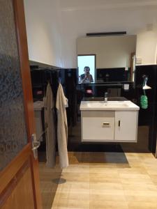 a bathroom with a sink and a person in a mirror at Viking Villa in Kalagedihena