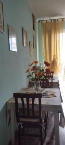 einen Esstisch mit Stühlen und eine Vase mit Blumen darauf in der Unterkunft Il Girasole in Rutigliano