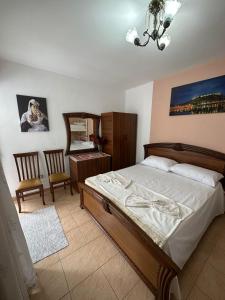 een slaapkamer met een bed, een bureau en een spiegel bij Cozy apartment in the City Center in Shkodër