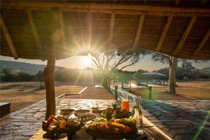 una mesa con comida en ella con el sol en el fondo en Zebras Crossing, en Modimolle