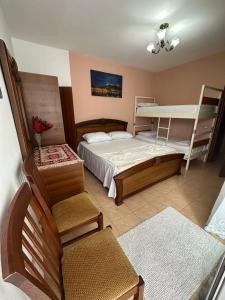 een slaapkamer met een bed en een stapelbed bij Cozy apartment in the City Center in Shkodër