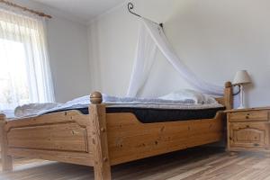 a bedroom with a wooden bed with a mosquito net at Staberhuk links - XL Ferienwohnung - Sonnendurchflutet - Terrasse in Staberdorf