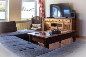 a living room with a tv and a coffee table at Staberhuk links - XL Ferienwohnung - Sonnendurchflutet - Terrasse in Staberdorf