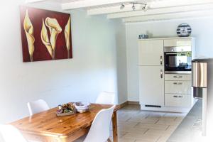 a kitchen with a wooden table and white chairs at Staberhuk links - XL Ferienwohnung - Sonnendurchflutet - Terrasse in Staberdorf