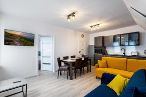 a living room with a yellow couch and a table at Mega widok 4 in Szklarska Poręba