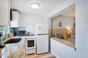 a kitchen with a white refrigerator and a sink at Upham Beach Inn - #3 Studio in St. Pete Beach