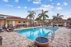 a pool at a resort with tables and chairs at Upham Beach Inn - #3 Studio in St. Pete Beach