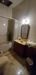 a bathroom with a sink and a mirror and a tub at Mi habitación en Salta cerca de todo ! in Salta