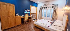 a bedroom with a bed and a desk and a television at Athirige Private Villa Dharavandhoo in Dharavandhoo