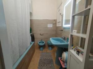 een badkamer met een blauw toilet en een wastafel bij Loggia58 in Trapani