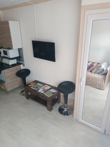 um quarto com uma mesa e dois bancos e uma cama em Appartement résidence Sarciron em Le Mont-Dore