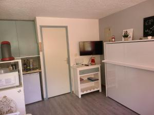 Dieses Zimmer verfügt über eine Küche mit einem Kühlschrank und einer Mikrowelle. in der Unterkunft Studio St Lary village-vue montagne. in Saint-Lary-Soulan