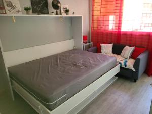 a large bed in a room with a couch at Studio St Lary village-vue montagne. in Saint-Lary-Soulan