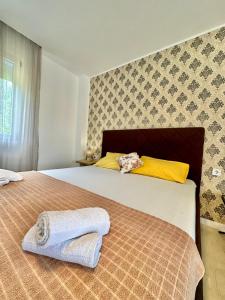 Montenegrina Apartment في بودفا: غرفة نوم عليها سرير وفوط
