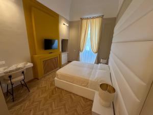 una camera con letto, scrivania e TV di Palazzo Bonomi a Bisceglie