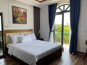 a bedroom with a bed and a large window at HÀ ANH hotel in Phường Sáu