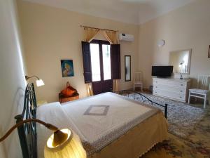 een slaapkamer met een bed, een dressoir en een raam bij Loggia58 in Trapani