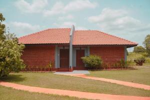 dom z czerwonej cegły z czerwonym dachem w obiekcie Foresta Resort Sigiriya w mieście Sigirija