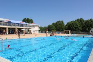 a group of people swimming in a swimming pool at Camping De Thoissey *** in Thoissey