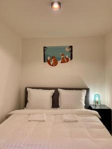 a bedroom with a large white bed with two pillows at Sluwe Vos: ontspannen in het bos! in Otterlo