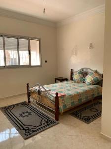 a bedroom with a bed and two rugs at Villa in Douar Ourlali