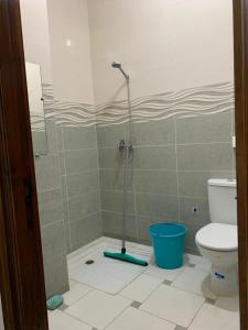 a bathroom with a shower with a toilet and a bucket at Villa in Douar Ourlali