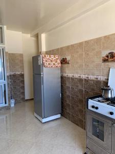Douar Ourlali的住宿－Villa，厨房配有不锈钢冰箱和炉灶。