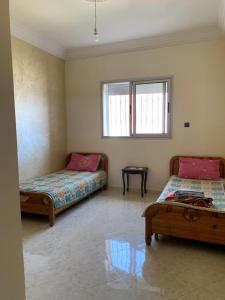 a bedroom with two beds and a window at Villa in Douar Ourlali