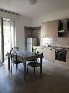 uma cozinha com uma mesa e cadeiras e um frigorífico em Casa di Nalo' em Termoli