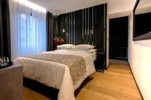 a bedroom with a large bed with white pillows at City Premium Heritage in Zadar