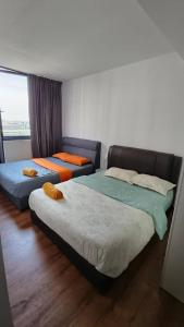 sypialnia z 2 łóżkami i kanapą w obiekcie Mupify Homestay Jazz Suites 2 Vivacity w mieście Kuching