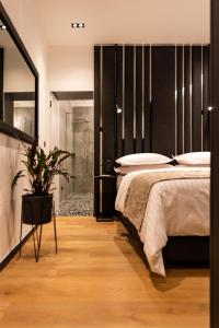 a bedroom with a large bed and a potted plant at City Premium Heritage in Zadar
