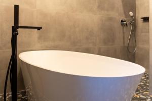 a white bath tub in a bathroom at City Premium Heritage in Zadar