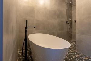 a bath tub in a bathroom with a shower at City Premium Heritage in Zadar