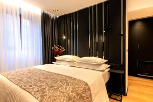 una camera da letto con un letto con pareti nere e cuscini bianchi di City Premium Heritage a Zara (Zadar)