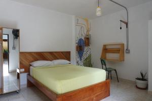 a bedroom with a bed and a chair in it at Amagua Hostel in Caracolí