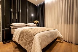 a bedroom with a bed with white sheets and pillows at City Premium Heritage in Zadar