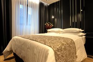 a bedroom with a bed with white sheets and a window at City Premium Heritage in Zadar