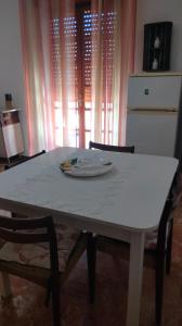 a white table with two chairs and a refrigerator at Appartamento Ida vacanza mare in Policoro