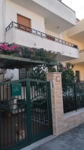 a building with a green gate and flowers on a balcony at Appartamento Ida vacanza mare in Policoro