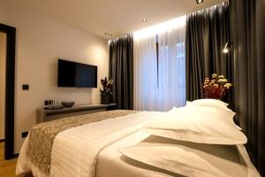 a hotel room with a bed and a television at City Premium Heritage in Zadar