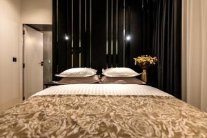 a bedroom with a large bed with white pillows at City Premium Heritage in Zadar