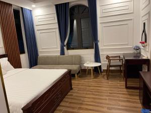 um quarto com uma cama, um sofá e uma secretária em HÀ ANH hotel em Phường Sáu