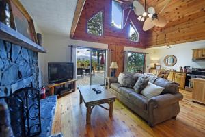 een woonkamer met een bank en een tv bij Big Pine - Long range mountain views, large decks, hot tub, fire pit and dog friendly! in Blairsville