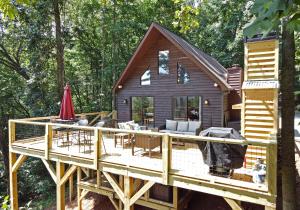 een blokhut met een terras in het bos bij Big Pine - Long range mountain views, large decks, hot tub, fire pit and dog friendly! in Blairsville